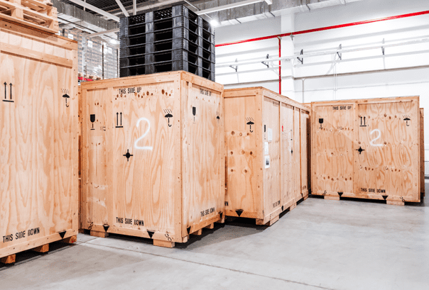 Gros caisses en bois sur palette empilées dans un entrepôt.